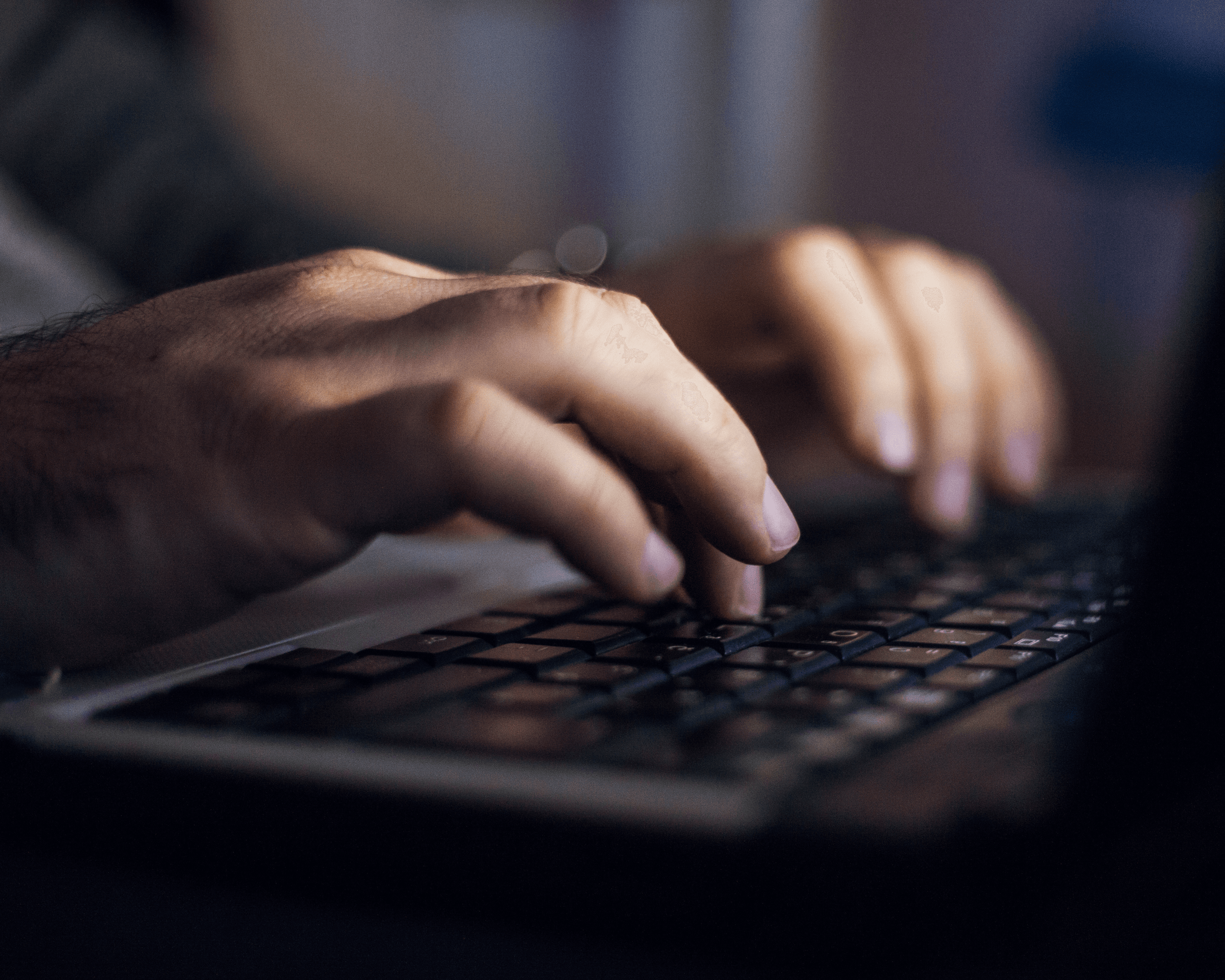 Hands of a man typing on a keyboard